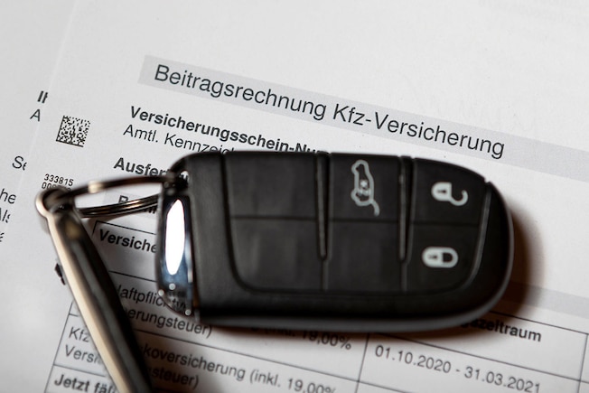 KFZ-Versicherung - Ein Autoschlüssel liegt auf einer Beitragsrechnung einer Kfz-Versicherung.